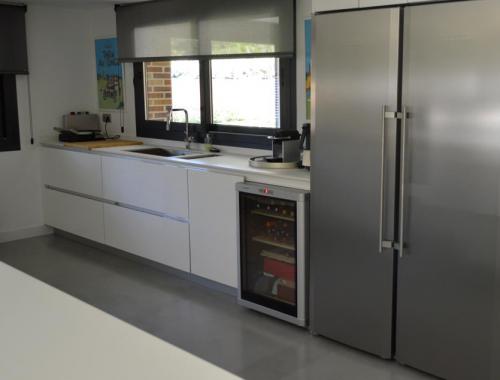 Cocina amplia que comunica con el exterior de la vivienda a través de una ventana corredera. 