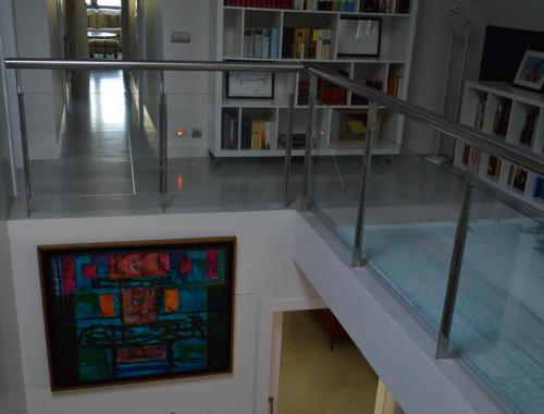 Escalera principal y primera planta de una propiedad dónde el suelo se ha reformado bajo la técnica del microcemento. 