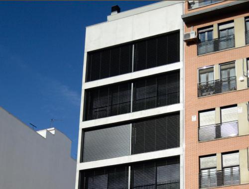 Fachada del edificio Ferrocarril 4BIS del arquitecto Israel Alba acristalada bajo unas correderas de aluminio. 