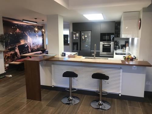 Cocina americana diseñada, ejecutada y amueblada por nuestro equipo en tonos grises y blancos.