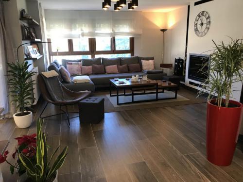 Salón amplio sobre suelo porcelánico aspecto madera que combina los colores dando un toque de modernidad.