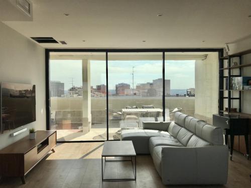 Balconera de tres hojas en aluminio negro mate situada en la cocina de este ático del centro de Madrid.
