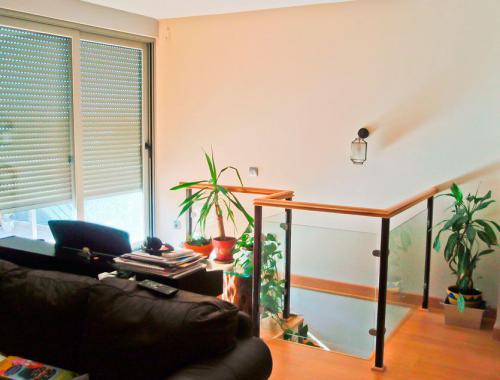 Ventana corredera de aluminio (izquierda) y barandilla (derecha) para el hueco de escalera en la planta superior de una vivienda.