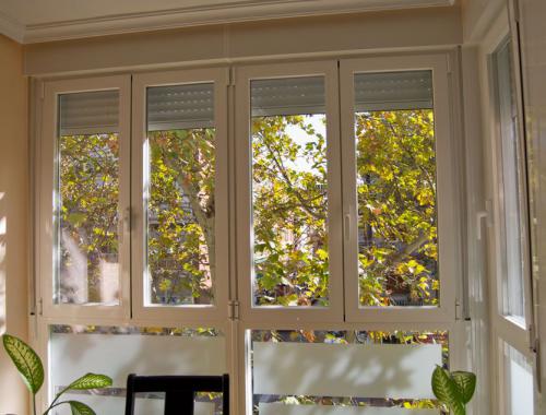 Ventana oscilobatiente de aluminio con ruptura de puente térmico en salón.