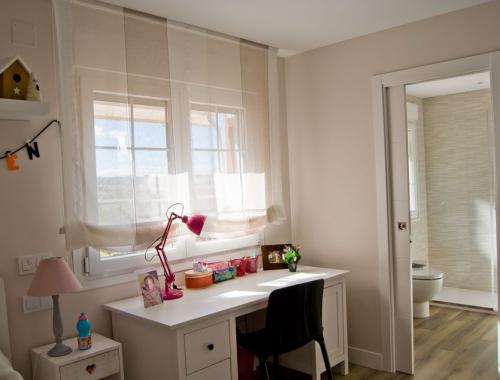 Ventana de PVC oscilobatiente con barrotillo en habitación infantil.