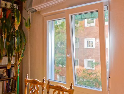 Ventana oscilobatiente de aluminio con ruptura de puente térmico en salón.